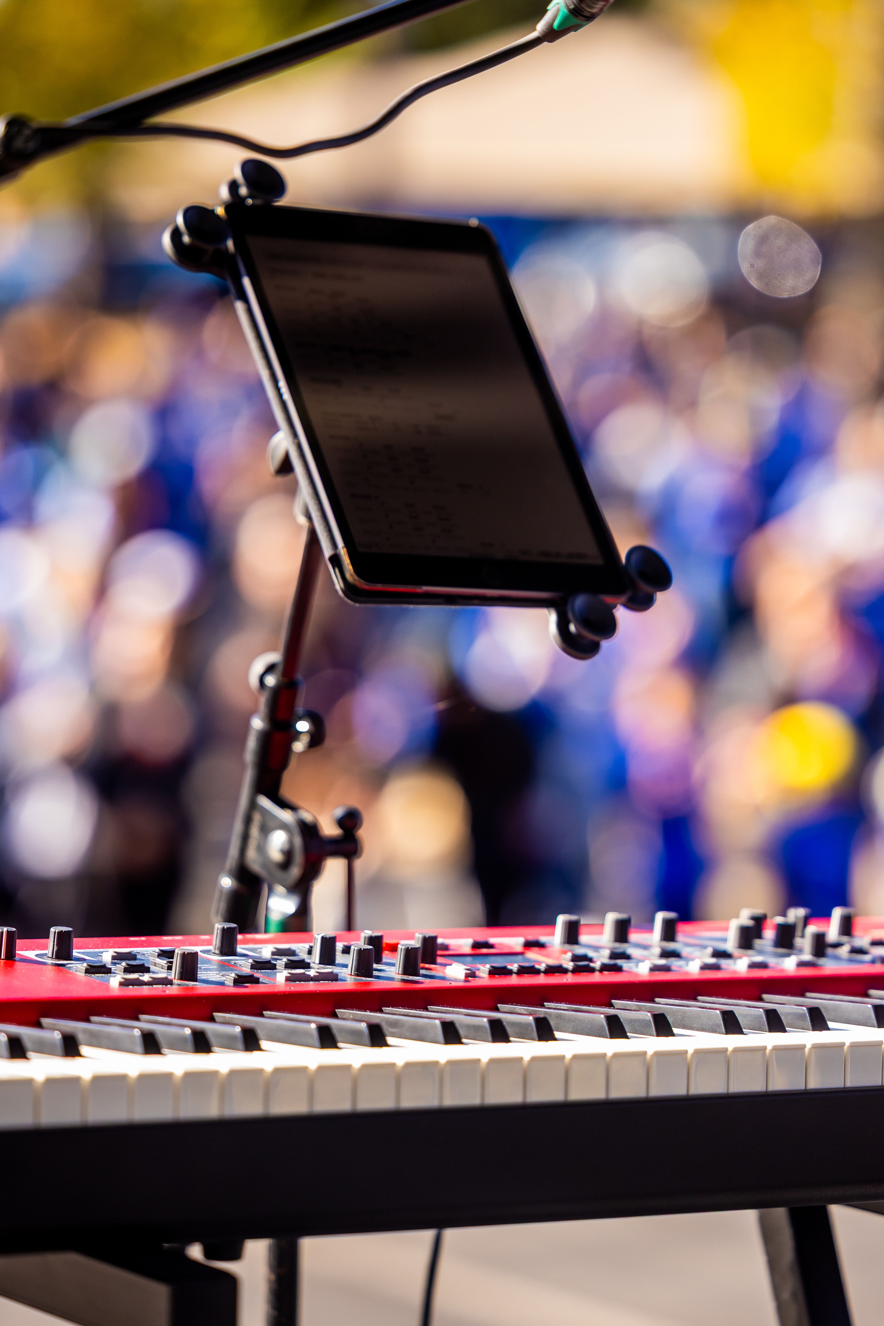 Electronic keyboard on stage with blurred crowd